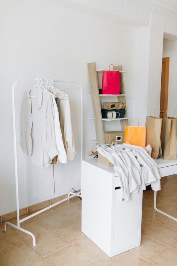 A modern interior with shopping bags, clothing rack, and minimalist design elements.